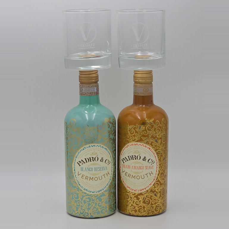 Two vermouth bottles with matching clear glasses on top, photographed against a plain light gray background. The bottle on the left is turquoise with gold ornamental patterning and a cream label reading 'PADRO & CO VERMOUTH'.