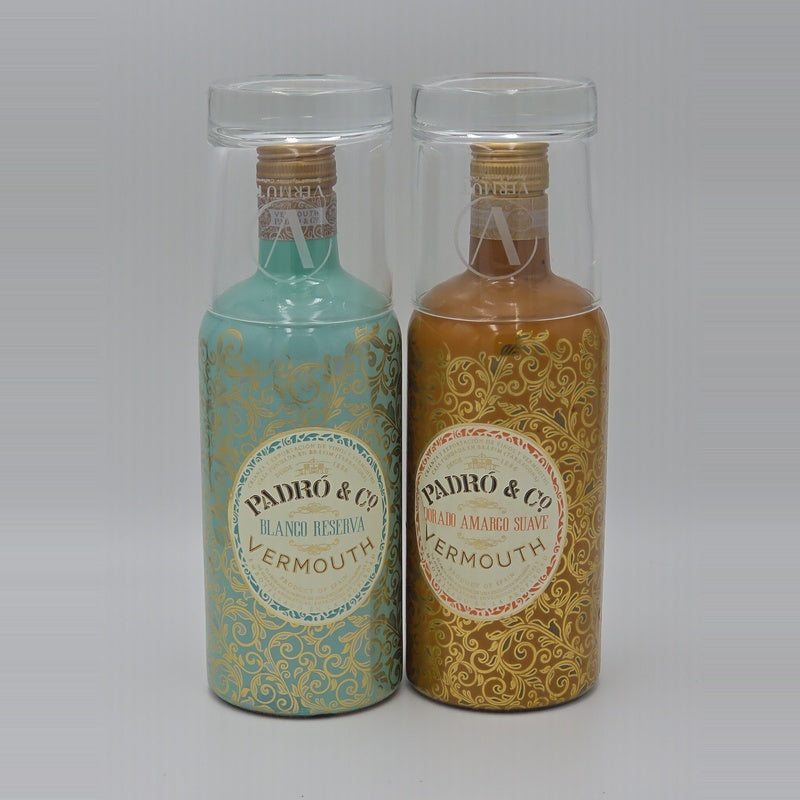 Two bottles of PADRO & CO Vermouth in clear plastic protective cases, one with a turquoise and gold patterned bottle and the other with a golden-brown and gold patterned bottle, set against a neutral gray background.
